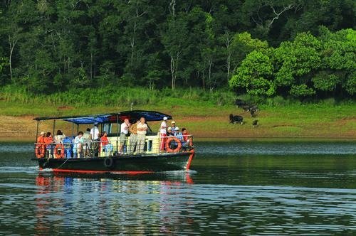 Tourist boat on Periyar Lake in Thekkady with forest on the shore